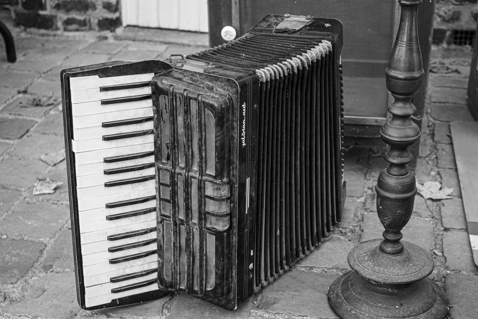 An old accordion rests on a stone surface.